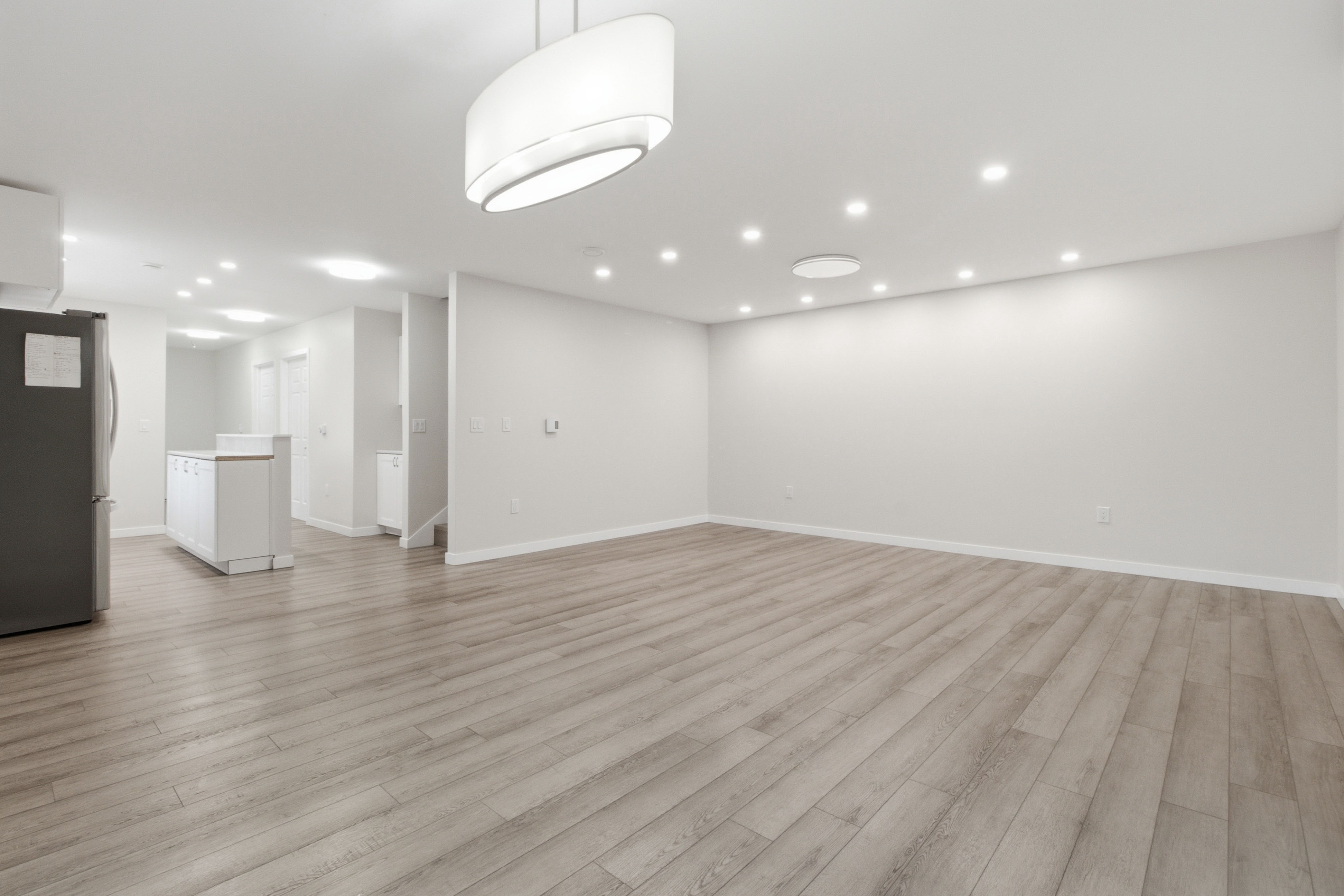 Expansive open-concept great room flowing from the kitchen, finished with recessed and pendant lighting